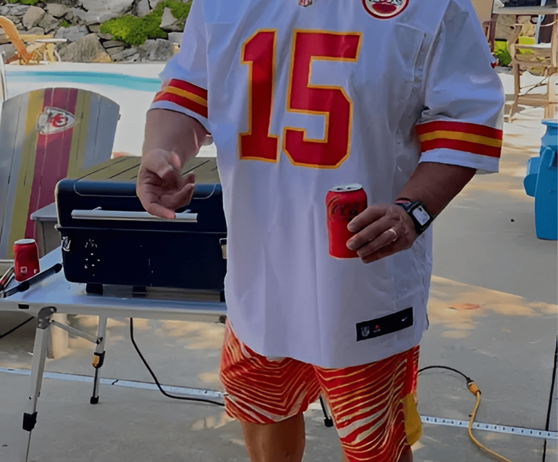 Person in sports jersey holding a drink.