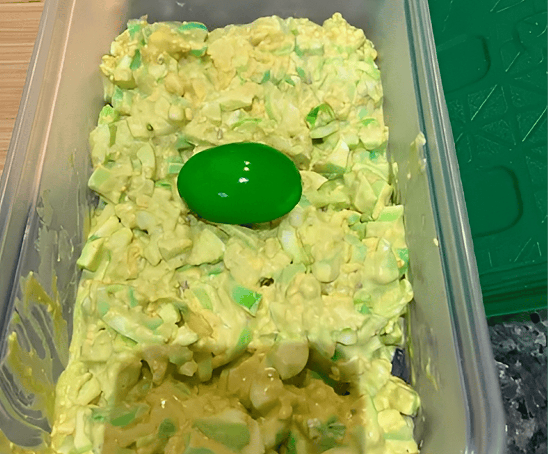 Egg salad with a green plastic egg.