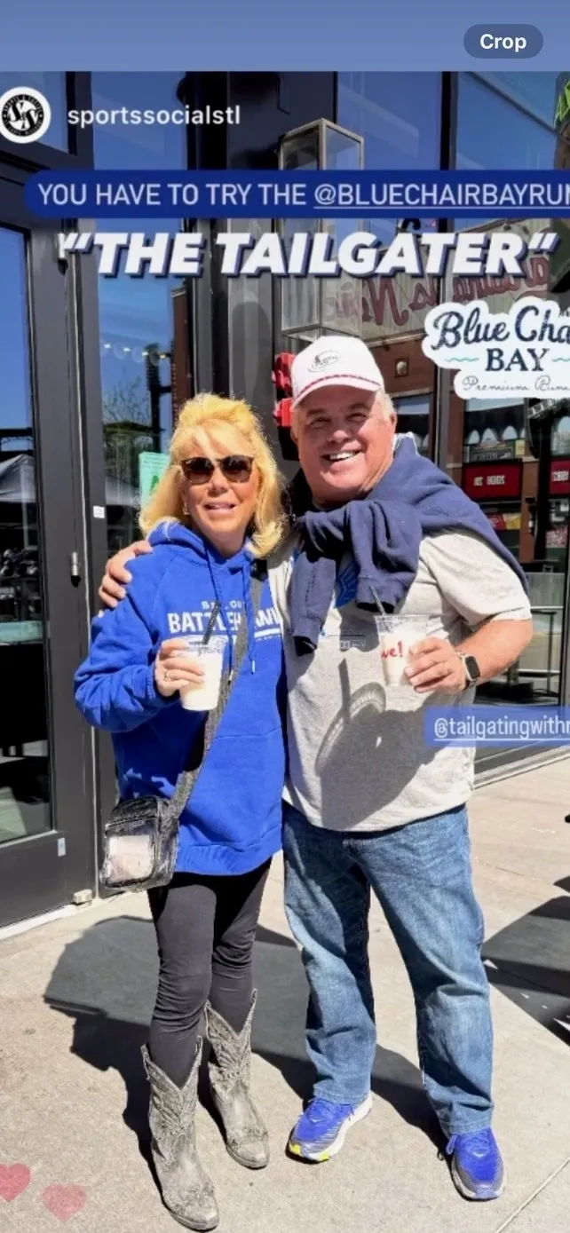 Two people smiling outside a restaurant.