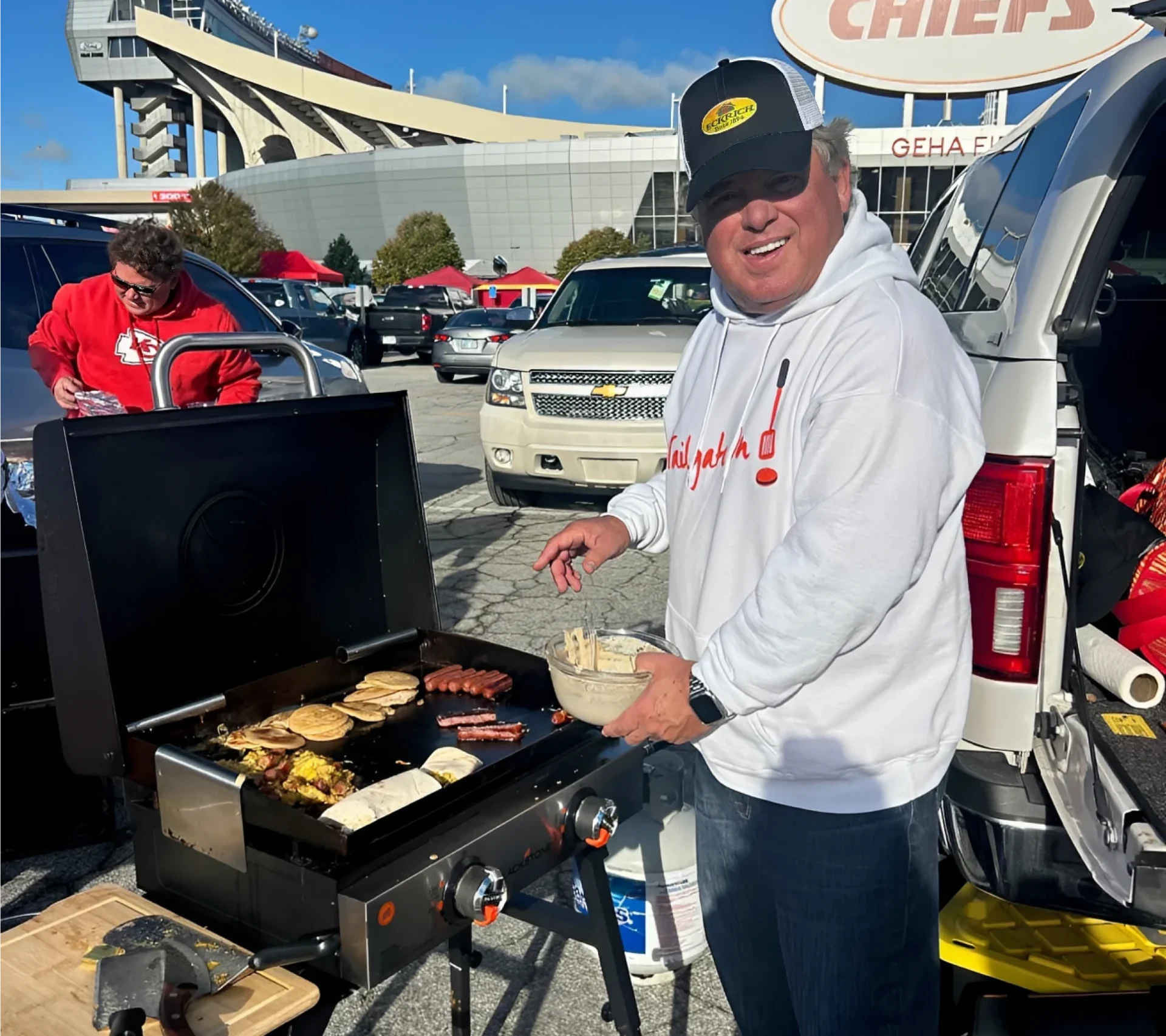 Man grilling food at a tailgate party.