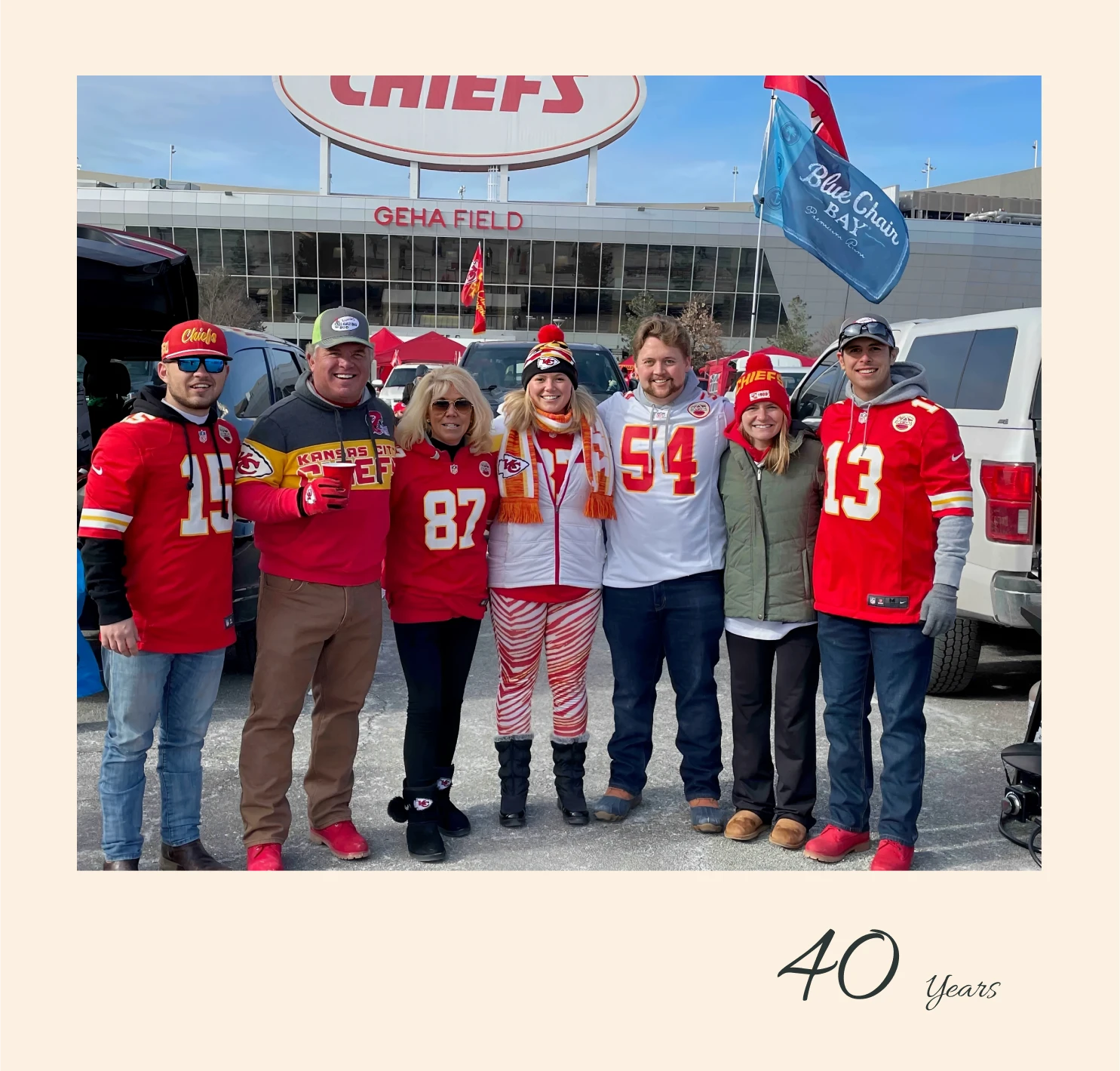 Group celebrating at a football stadium tailgate.