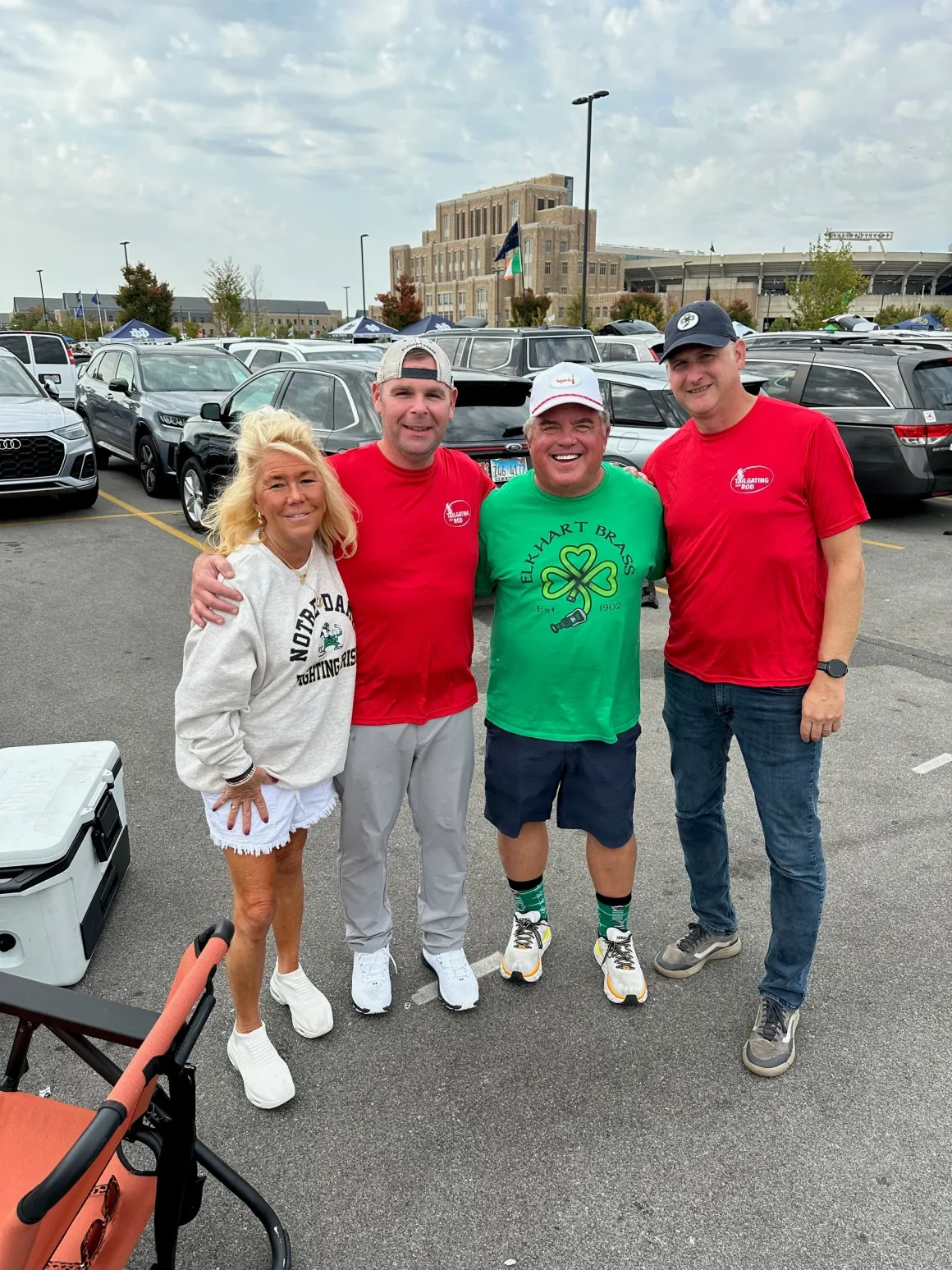 Group of four people smiling in parking lot.