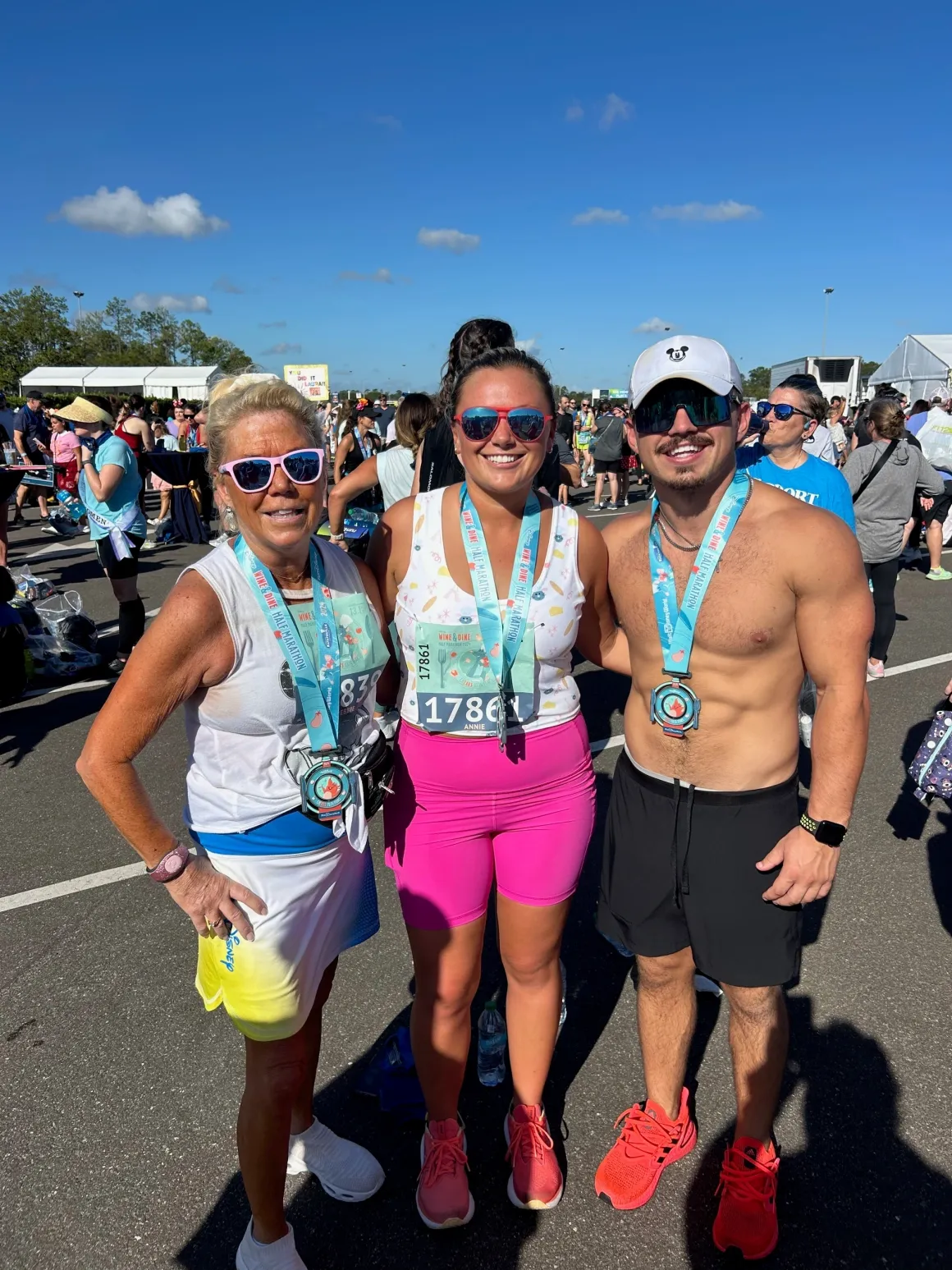 Three people wearing race medals outside.