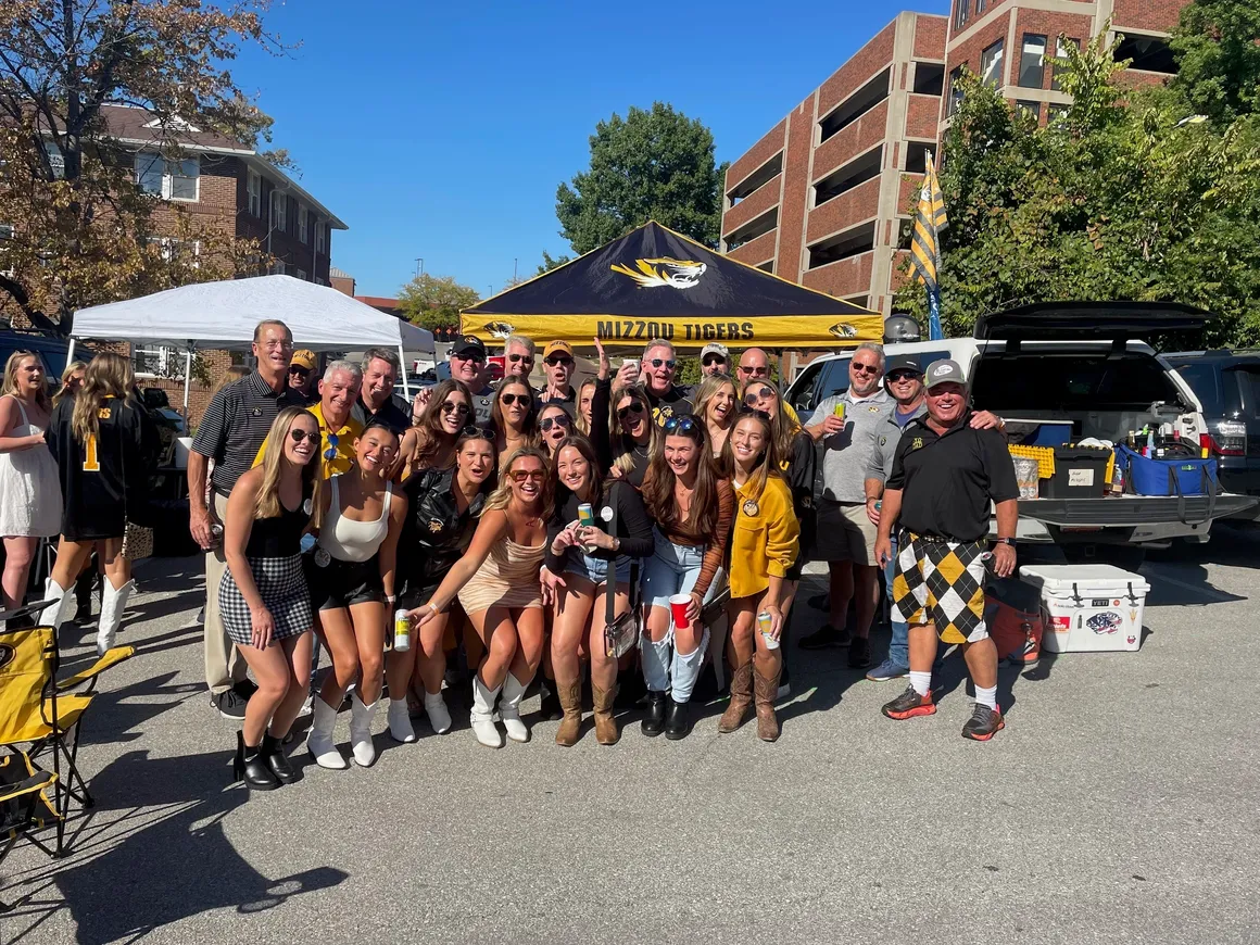 Group of people at outdoor tailgate event.