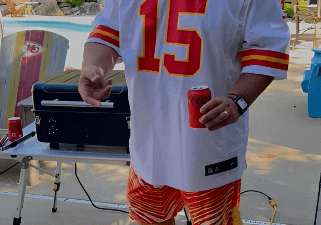 Person in sports jersey holding a drink.