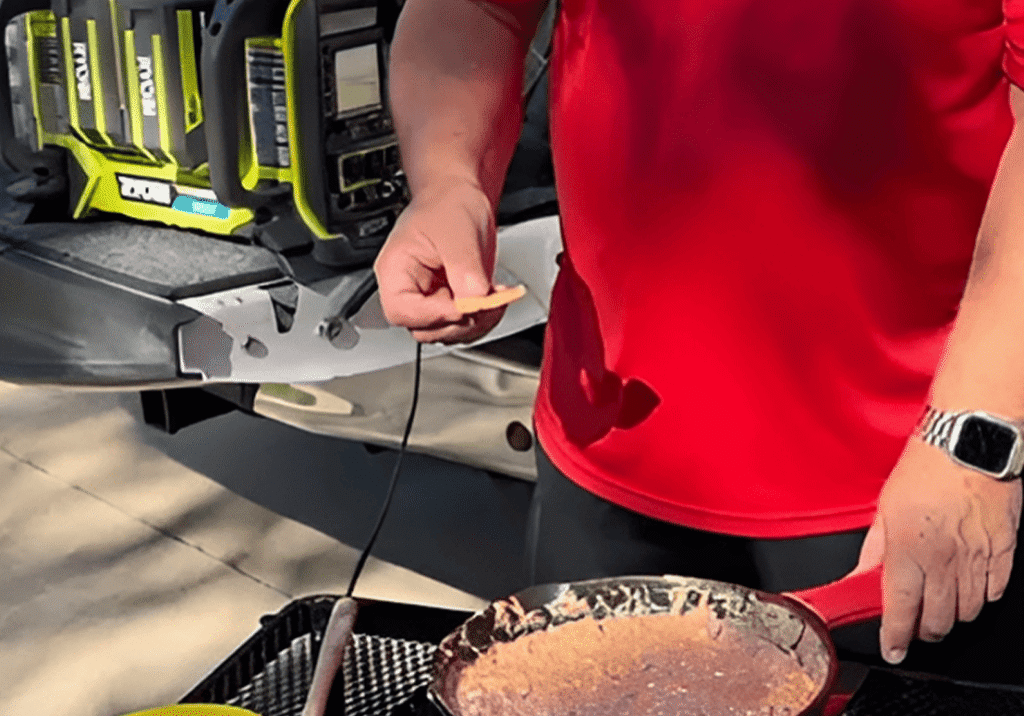 Person cooking outdoors with portable power station.